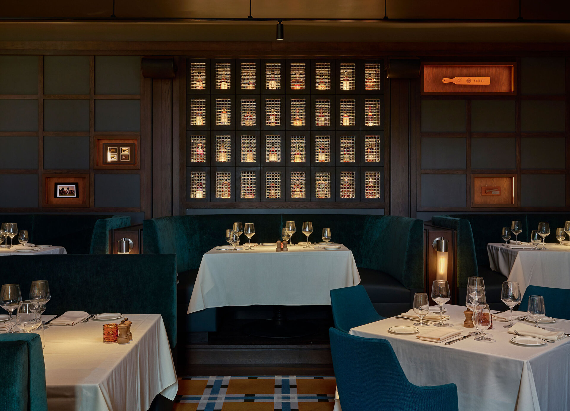 Boilerhouse — wine display wall framed by paneled walls and banquettes
