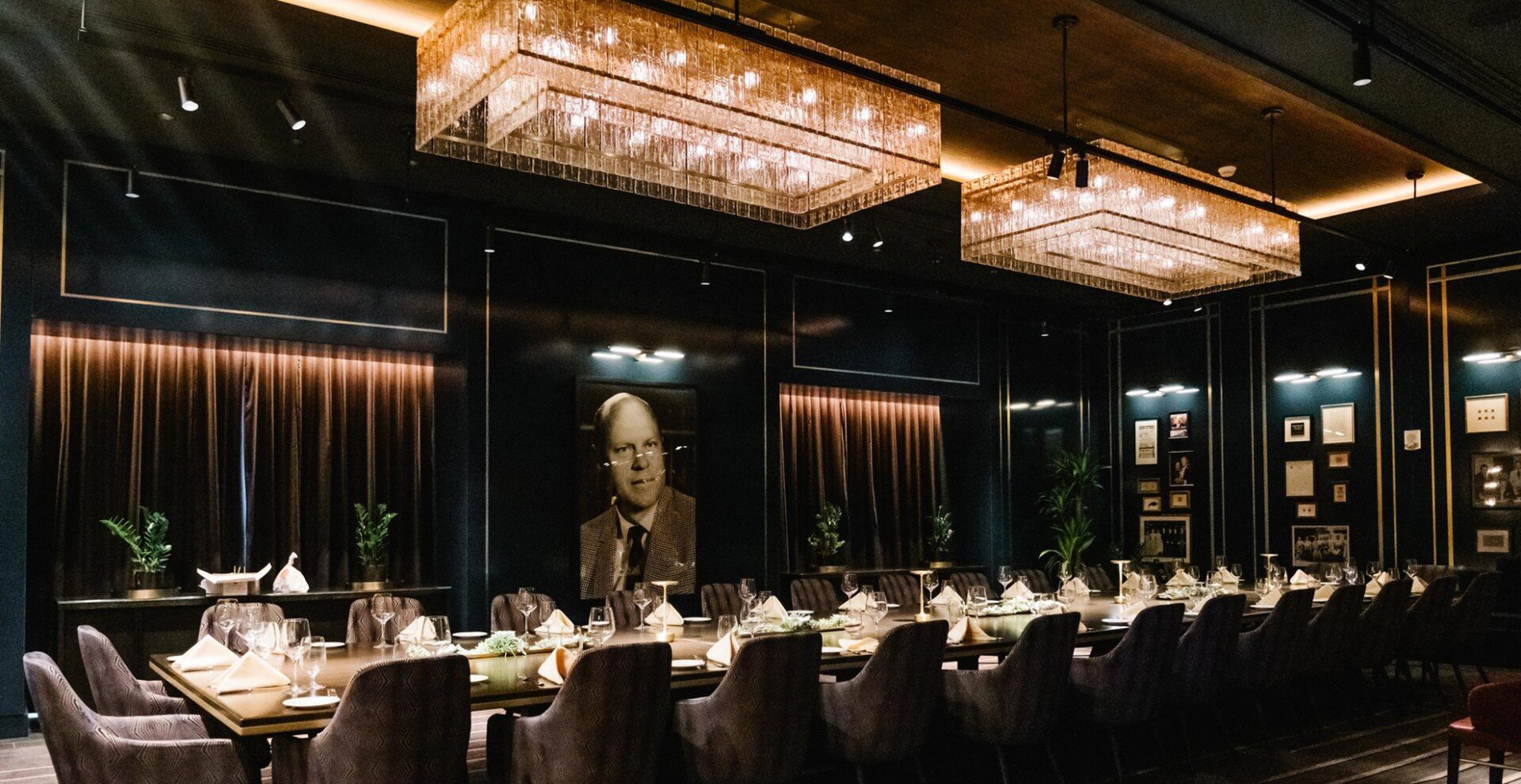 Private dining room with custom millwork, dark walls, and integrated lighting